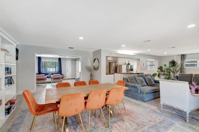 dining space with light wood-type flooring, visible vents, and recessed lighting