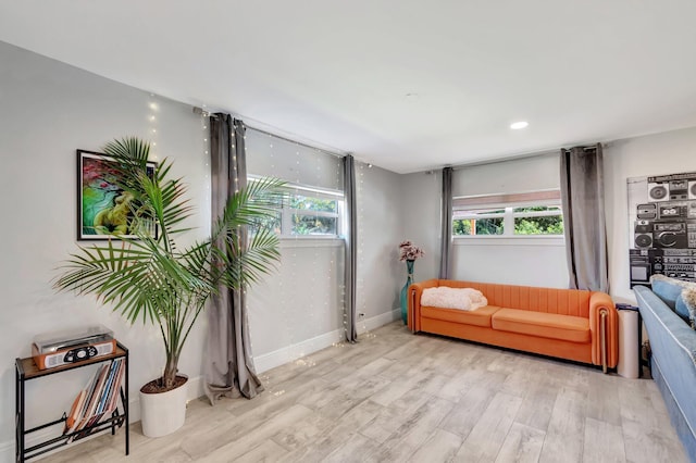 sitting room featuring a healthy amount of sunlight, baseboards, and wood finished floors