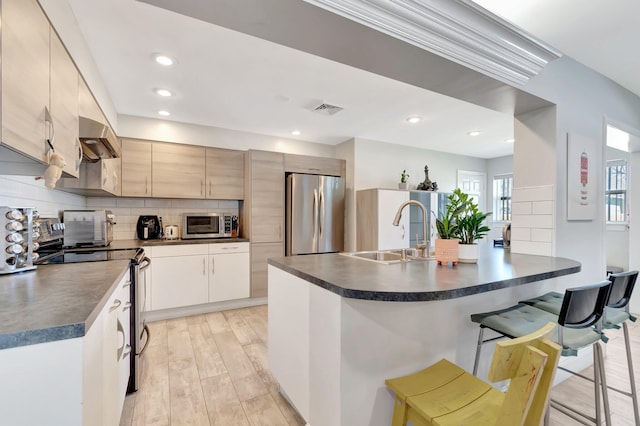 kitchen featuring dark countertops, visible vents, appliances with stainless steel finishes, and a sink