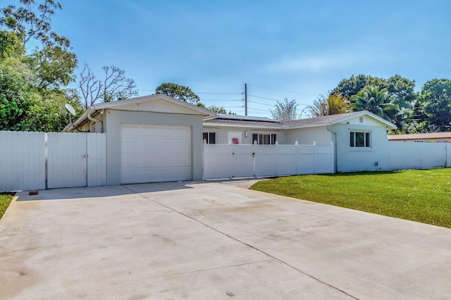 ranch-style home with solar panels, a fenced front yard, a garage, driveway, and a gate