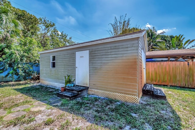 view of outbuilding with an outbuilding, fence, and entry steps