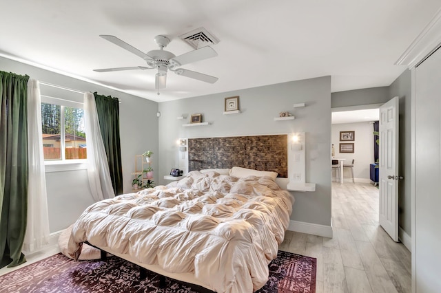 bedroom with light wood-type flooring, baseboards, visible vents, and ceiling fan