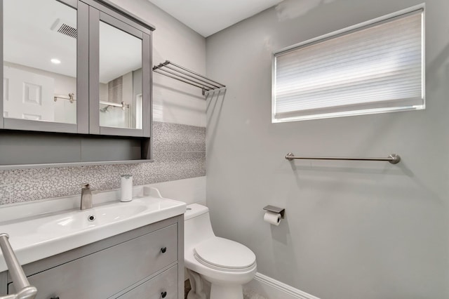 bathroom with baseboards, visible vents, vanity, and toilet