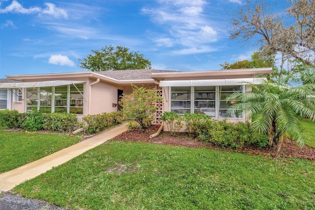 view of front of property with stucco siding and a front yard