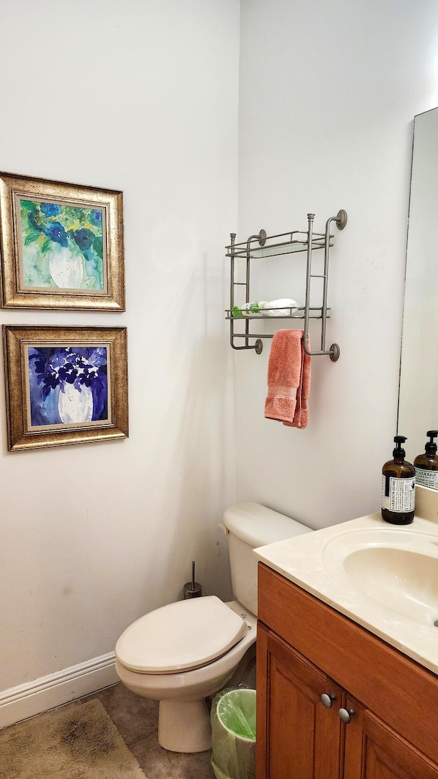 half bathroom with toilet, vanity, and baseboards