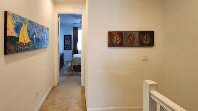 hallway featuring baseboards and carpet floors