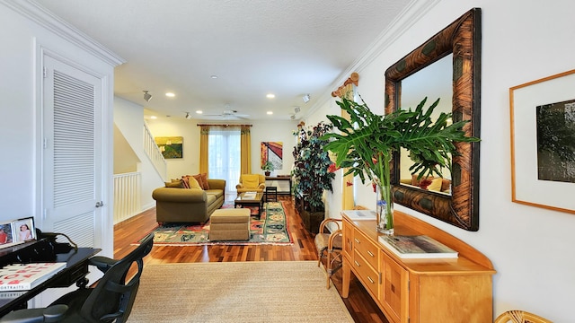 living room with a ceiling fan, wood finished floors, recessed lighting, crown molding, and stairs