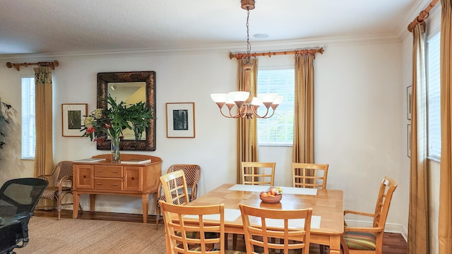 dining area with a notable chandelier, baseboards, light wood-style floors, and crown molding