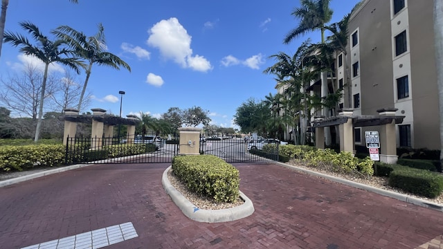 view of street featuring a gated entry, curbs, and a gate