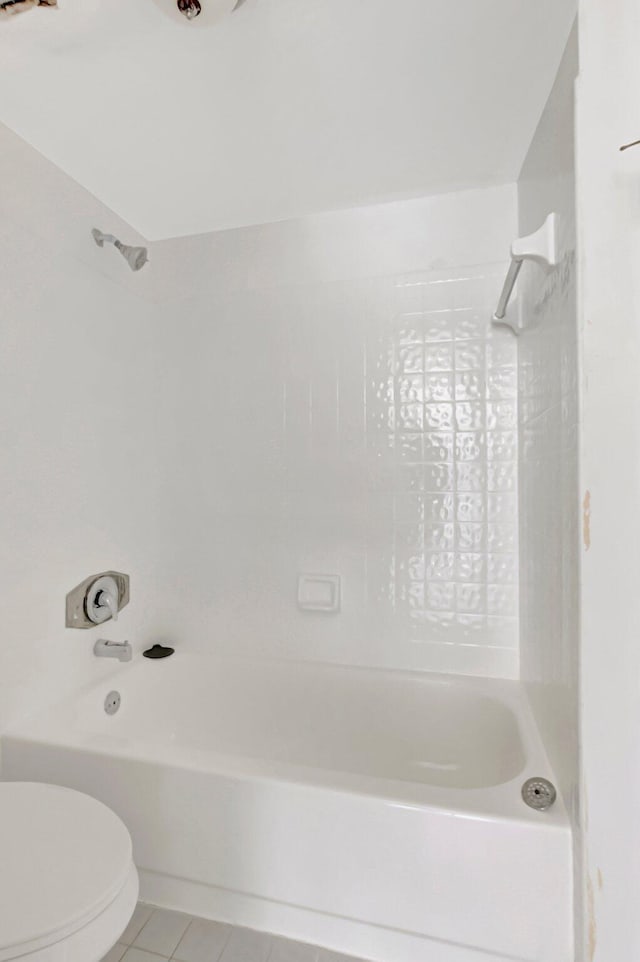 bathroom with washtub / shower combination, tile patterned flooring, and toilet