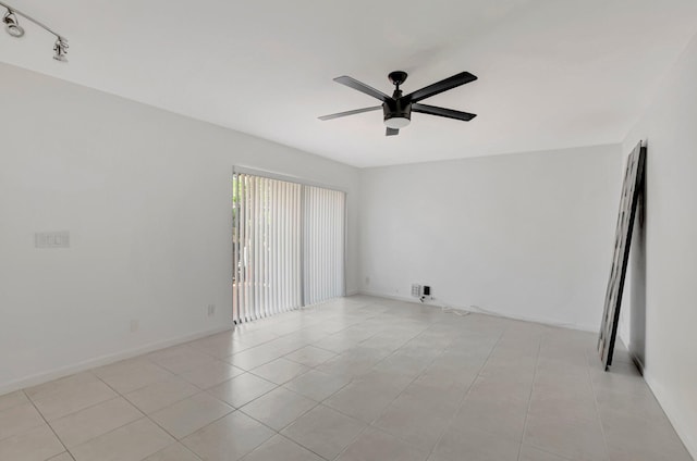 spare room with ceiling fan and light tile patterned flooring