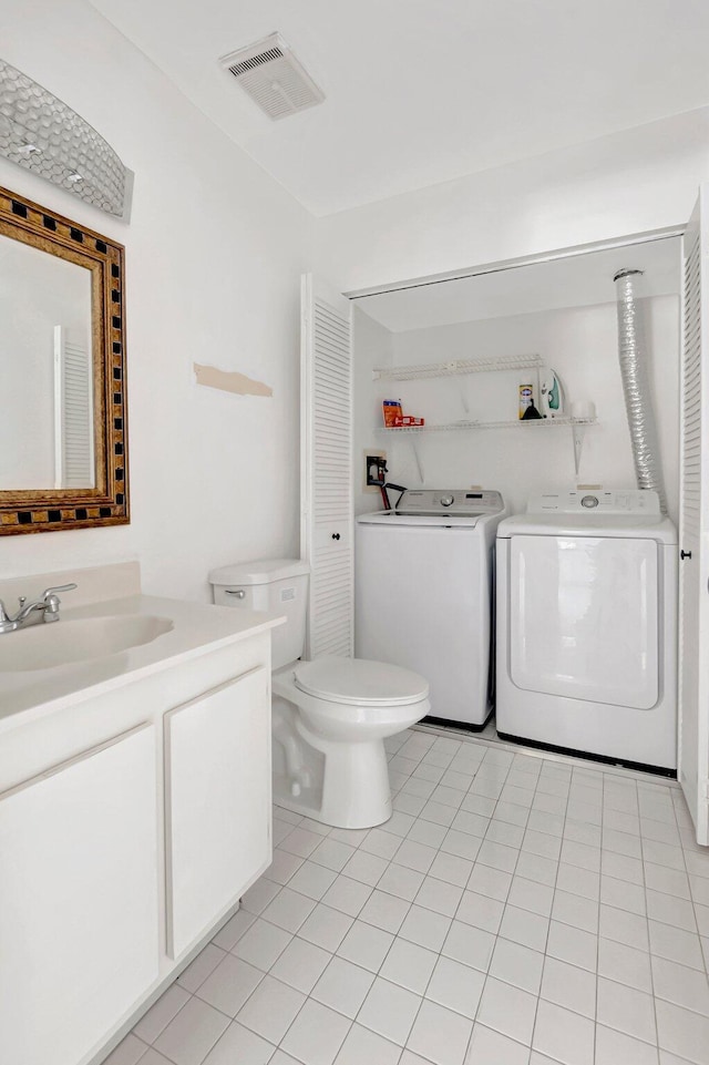 bathroom featuring washer and clothes dryer, visible vents, toilet, vanity, and tile patterned floors