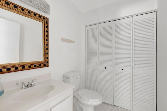 bathroom featuring a closet, vanity, toilet, and tile patterned floors