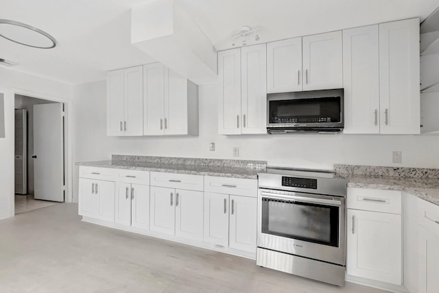 kitchen with white cabinets, light stone countertops, and stainless steel appliances