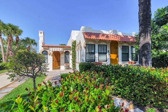 mediterranean / spanish house with a tiled roof and stucco siding