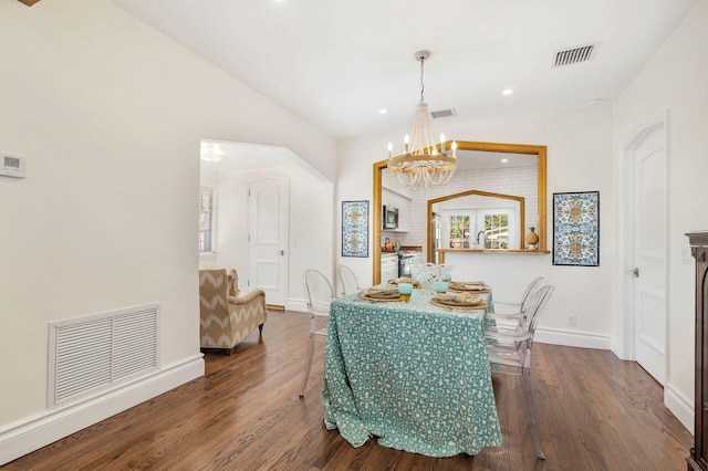 dining room featuring a notable chandelier, visible vents, and wood finished floors