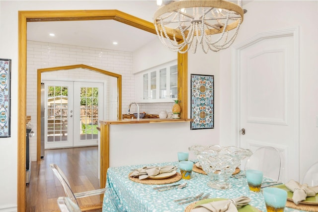 dining room with french doors, recessed lighting, wood finished floors, and a notable chandelier