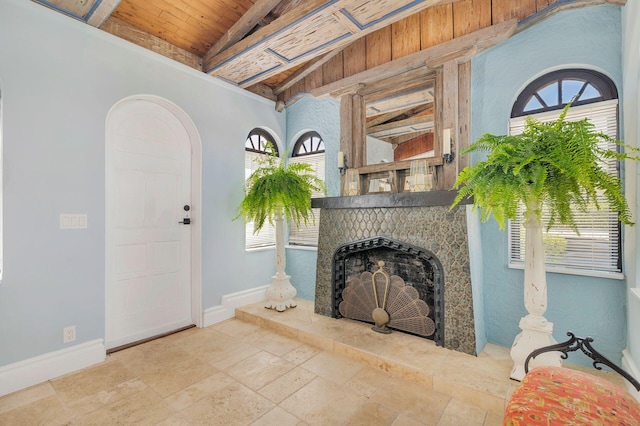 living room featuring a fireplace with raised hearth, a healthy amount of sunlight, and baseboards