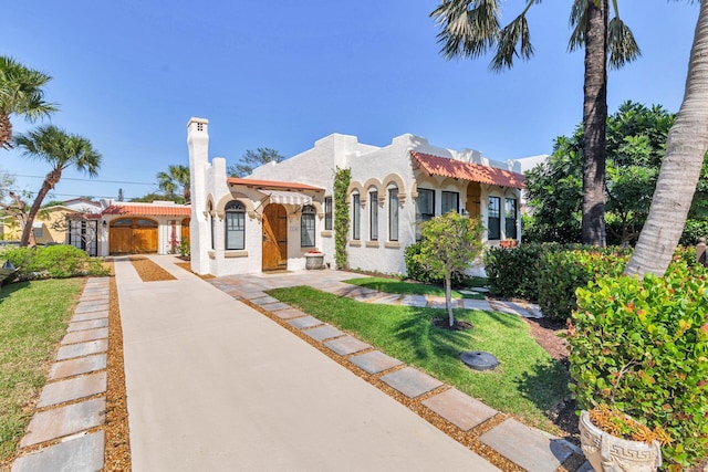 view of front of home with a front yard and stucco siding