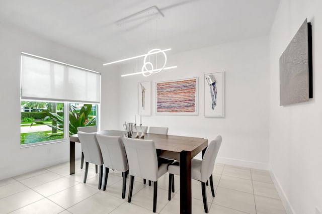 dining room featuring light tile patterned floors, a notable chandelier, and baseboards