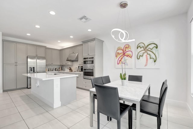 kitchen with visible vents, a sink, stainless steel appliances, gray cabinetry, and under cabinet range hood