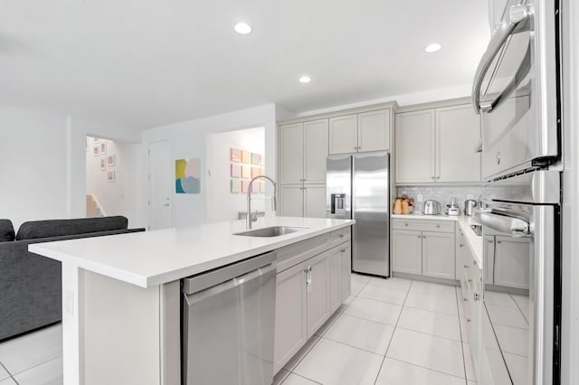 kitchen featuring light tile patterned flooring, appliances with stainless steel finishes, light countertops, and a sink