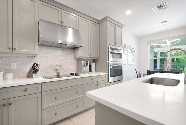 kitchen with visible vents, stainless steel double oven, a sink, under cabinet range hood, and black electric stovetop