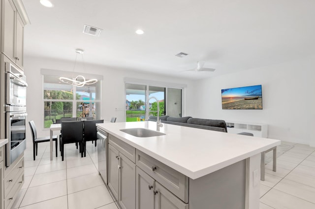 kitchen featuring visible vents, light tile patterned flooring, a sink, light countertops, and appliances with stainless steel finishes