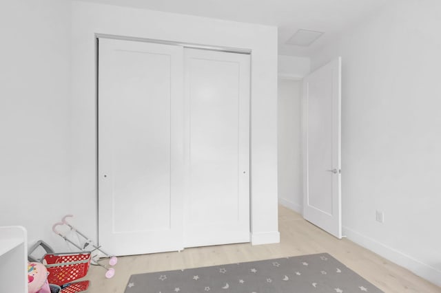 unfurnished bedroom with visible vents, baseboards, light wood-style floors, and a closet