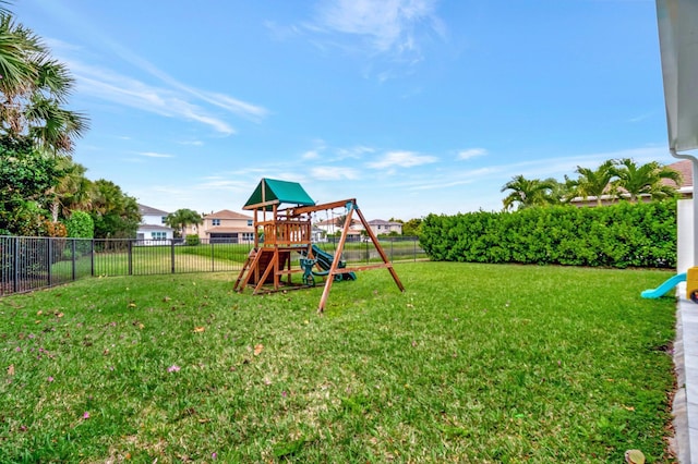 view of playground featuring a lawn and fence