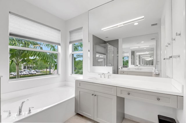 full bathroom with vanity, a shower stall, a bath, and visible vents