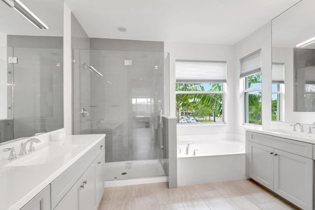 full bathroom with a shower stall, two vanities, and a sink