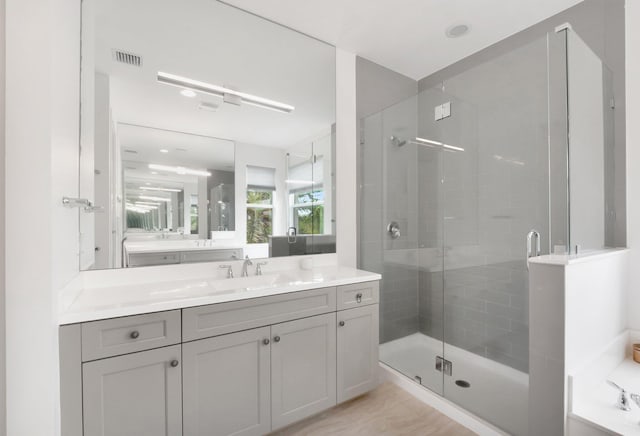 bathroom with visible vents, vanity, and a shower stall