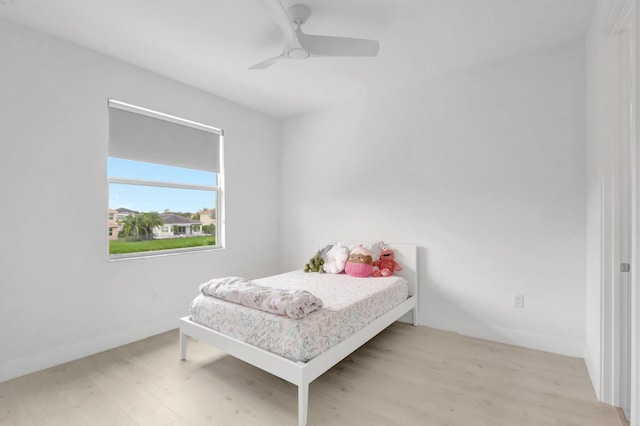 bedroom featuring light wood-type flooring, baseboards, and ceiling fan