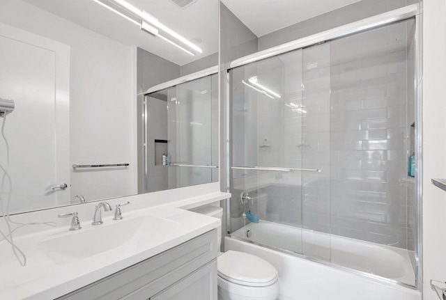 full bathroom featuring visible vents, enclosed tub / shower combo, toilet, and vanity