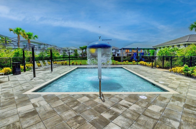 view of pool featuring a fenced in pool, fence, playground community, and a patio area