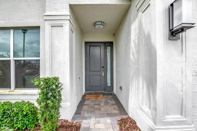 entrance to property featuring stucco siding