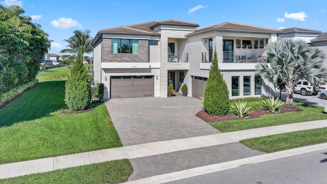 view of front of home featuring driveway, a front lawn, an attached garage, and stucco siding