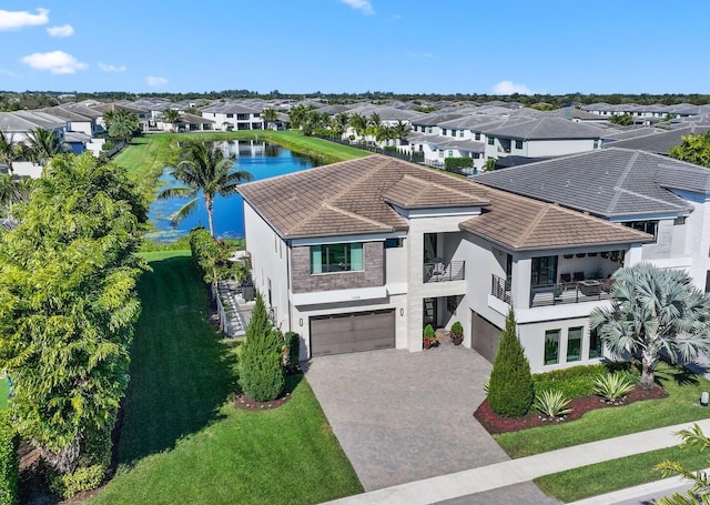 view of front of property featuring a garage, decorative driveway, a water view, and a residential view