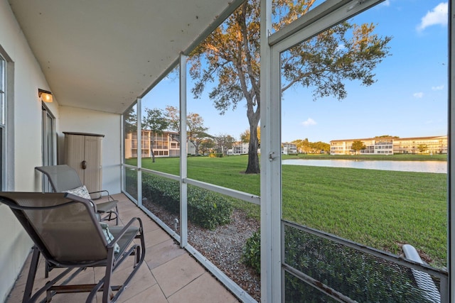 sunroom featuring a water view