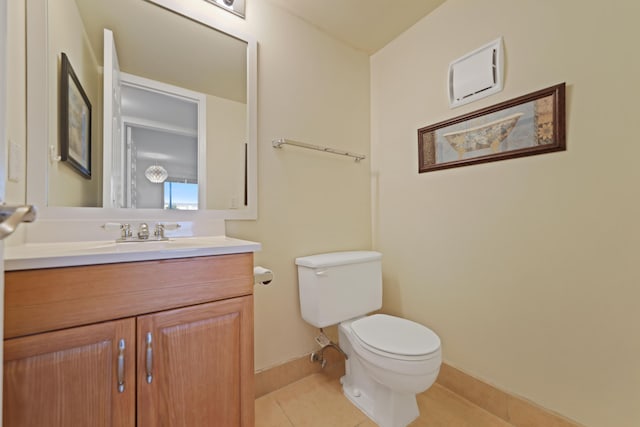 bathroom with tile patterned flooring, baseboards, vanity, and toilet