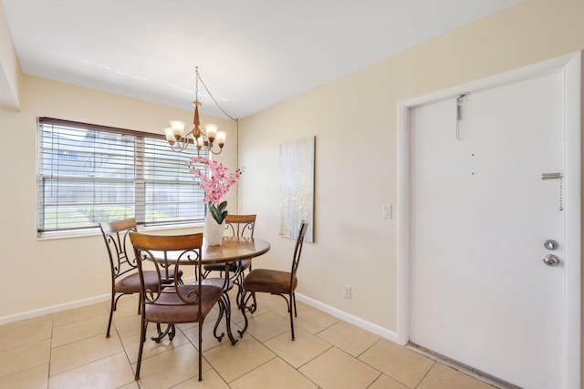 dining area with lofted ceiling, an inviting chandelier, baseboards, and light tile patterned flooring