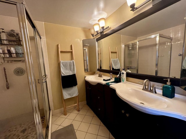 full bath featuring a sink, double vanity, a shower stall, and tile patterned floors