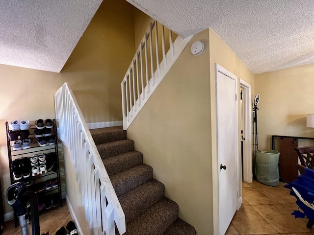 staircase featuring a textured ceiling and tile patterned floors