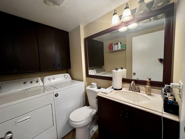 bathroom with toilet, washing machine and dryer, and vanity