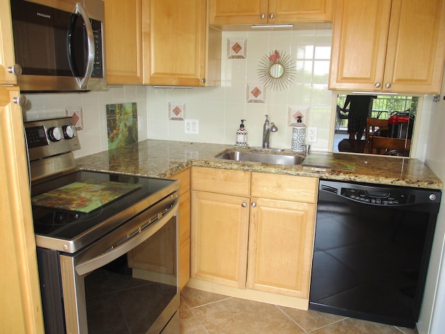 kitchen featuring backsplash, dark stone counters, stainless steel appliances, and a sink