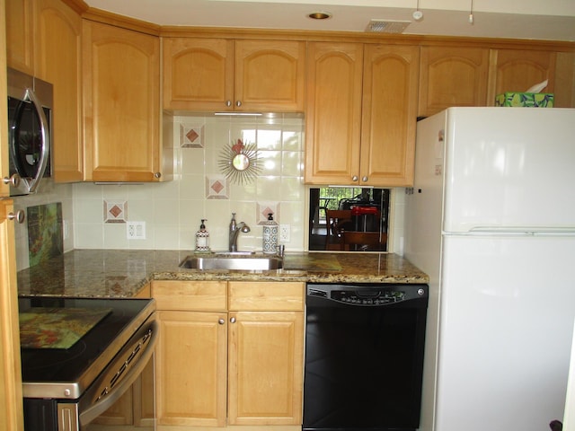 kitchen featuring a sink, visible vents, appliances with stainless steel finishes, dark stone counters, and tasteful backsplash