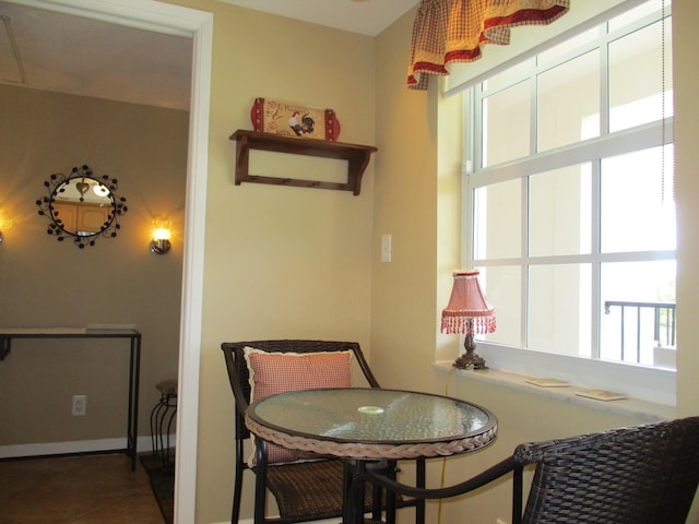 tiled dining area featuring baseboards