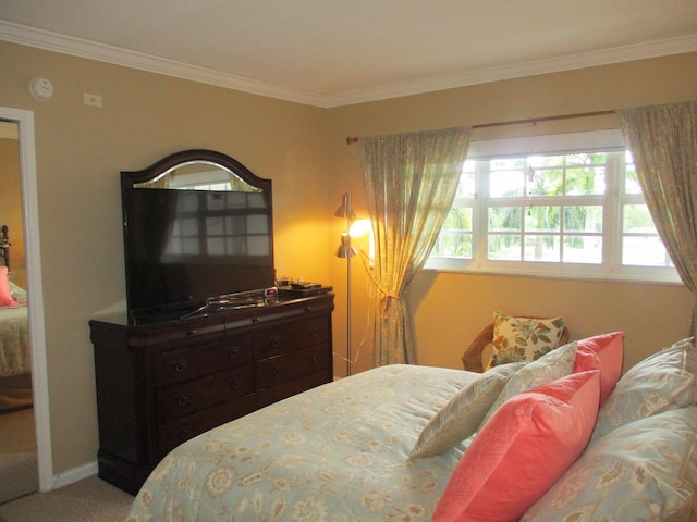 carpeted bedroom featuring crown molding and baseboards