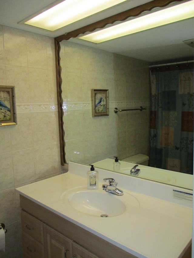 full bathroom with vanity and tile walls